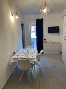 a dining room with a white table and chairs at Terrasini Sea in Terrasini