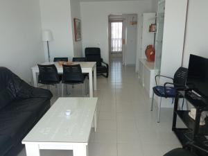un salon avec un canapé, une table et des chaises dans l'établissement VENECIA AZUL, sunny terrace & beautiful sea views, à La Manga del Mar Meno
