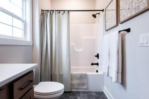 a white bathroom with a toilet and a shower at Brand New House! Prime Location! in Jeffersonville +30 photos