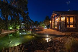 El ÁlamoにあるVilla Oasis Madridの夜の家の前の池