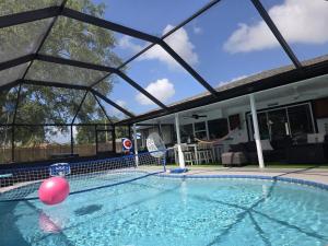 a swimming pool with a pink ball in the water at PoolSide Paradise in Port Saint Lucie