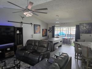a living room with a couch and a dining room at PoolSide Paradise in Port Saint Lucie