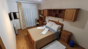 a small bedroom with a bed and a television at Quinta da Casinha Homestay in Pombal