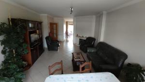 a living room with a black leather couch and chairs at Quinta da Casinha Homestay in Pombal