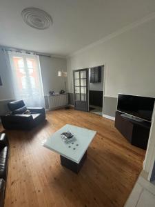 a living room with a couch and a coffee table at Maison 5mn du centre ville du Mans à pied in Le Mans