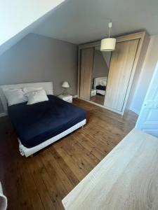 a bedroom with a blue bed and wooden floors at Maison 5mn du centre ville du Mans à pied in Le Mans