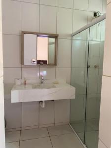 a bathroom with a sink and a glass shower at Casa tropical in Pirassununga +21 photos