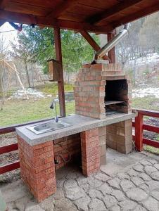 eine Außenküche mit einer Spüle und einem Backofen im Freien in der Unterkunft Casa din Săcădat-Szakadáti Vendégház in Sovata