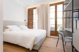 a bedroom with a bed and a desk and a window at Art Experience B&B "Hotel Boutique" in Vinarós