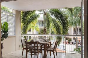 a dining room with a table and chairs on a balcony at Sleek apartment overlooking pool in Noosa Heads