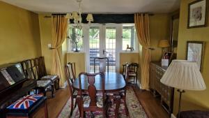 a dining room with a table and chairs and a window at Lavender Cottage in Chertsey