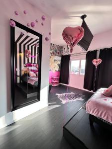 a pink room with pink hearts and a mirror at Maison 60 m2 Loveroom romantique avec jacuzzi privé à 10 min de Nancy et jardin privé in Messein +15 photos