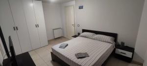 クアルトゥ・サンテーレナにあるPorzione di villetta a Capitanaのベッドとタオル2枚のある寝室