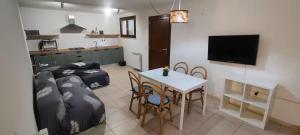 クアルトゥ・サンテーレナにあるPorzione di villetta a Capitanaのソファとテーブルと椅子のあるリビングルーム