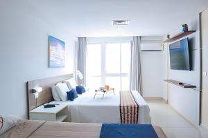 une chambre d'hôtel avec un lit et une télévision dans l'établissement Paraíso beira-mar em Tambaú! Nobile Suites #508, à João Pessoa