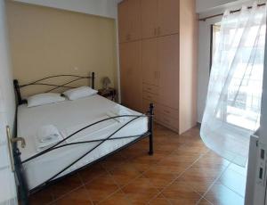 a bedroom with a bed and a large window at Areopoli home 7 in Areopoli