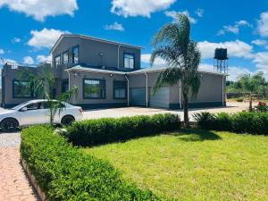 ein Haus mit einem davor geparkten Auto in der Unterkunft kafue Executive Family Residence in Kafue