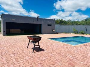 ein Grill vor einem Gebäude mit Swimmingpool in der Unterkunft kafue Executive Family Residence in Kafue