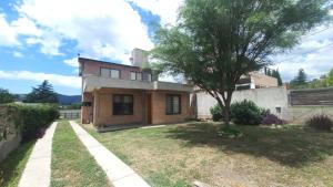 ein Haus mit einem Baum im Hof in der Unterkunft Casa Amsterdam in Villa Carlos Paz