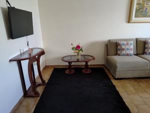 a living room with a couch and a table at Apê Aconchego in Vitória da Conquista