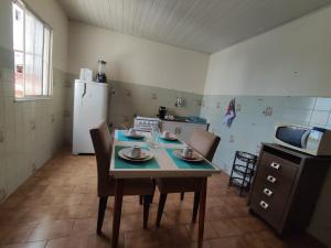 a kitchen with a table and chairs and a refrigerator at Apê Aconchego in Vitória da Conquista