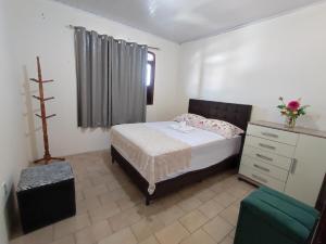 a bedroom with a bed and a dresser in it at Apê Aconchego in Vitória da Conquista +6 photos