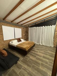 a bedroom with a bed and a brick wall at Cabañas La Sanguina, Loft H1 in Ocaña +15 photos