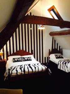 een slaapkamer met 2 bedden op een zolder bij The Swan Taphouse in Ironbridge