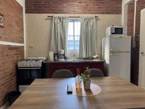 eine Küche mit einem Tisch und einem weißen Kühlschrank in der Unterkunft Casa en Paso de la Patria in San Cosme