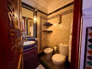 un piccolo bagno con un water e un lavandino di Kassr Annoujoum - Luxury Boutique Riad in the Heart of Fès Medina a Fes Altre 13 foto