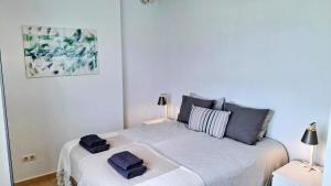 a white bedroom with a bed with two towels on it at Carmen Apartamento Eleanora in Nerja