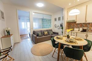 Una cocina y una sala de estar con una mesa y un sofá. en ARK Apartaman Sárvár, en Sárvár