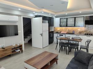 a kitchen and living room with a table and a couch at Villa BB Mugla 1 in Ortaca