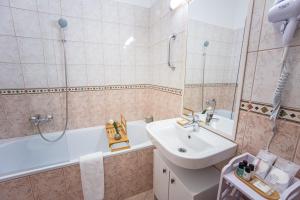 y baño con lavabo, bañera, aseo y lavamanos. en ARK Apartaman Sárvár, en Sárvár 16 fotos más