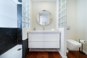 ein Badezimmer mit einem weißen Waschbecken und einem Spiegel in der Unterkunft Vista Roses Mar - Cases del Far in Roses + 44 Fotos