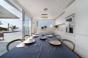 ein Esszimmer mit einem blauen Tisch und Stühlen in der Unterkunft Vista Roses Mar - Cases del Far in Roses