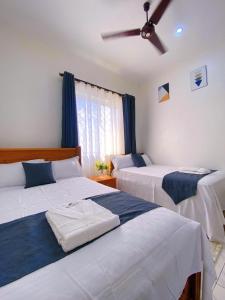 a bedroom with two beds and a ceiling fan at Residence, Bamburi in Mombasa