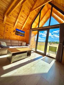 a living room with a couch and a large window at Eternum Glamping in Žabljak