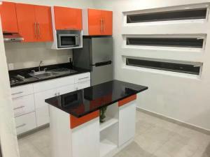 a kitchen with orange cabinets and a black counter top at Departamento A Fracc Cd Del Valle in Tepic +7 photos