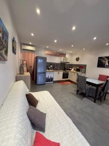 La Roquette-sur-Siagneにある2 pièces dans villa avec piscine parking à 10 mins de Cannesの広いリビングルーム(ベッド1台付)、キッチンが備わります。