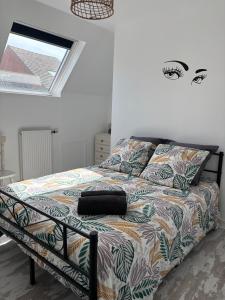 ein Schlafzimmer mit einem Bett mit einer bunten Bettdecke in der Unterkunft Chez Valentine in Grand-Fort-Philippe