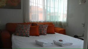 a bed with two towels on it with a window at Departamento "A" Fracc Cd Del Valle in Tepic