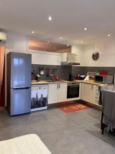 La Roquette-sur-Siagneにある2 pièces dans villa avec piscine parking à 10 mins de Cannesの白いキャビネットとステンレス製の冷蔵庫を備えたキッチン +14枚の写真