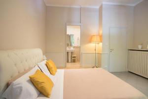 1 dormitorio con 1 cama blanca grande con almohadas amarillas en B&B Le Grazie, en Bérgamo
