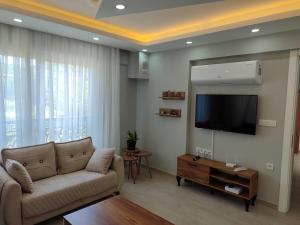 a living room with a couch and a flat screen tv at Villa BB Mugla 1 in Ortaca