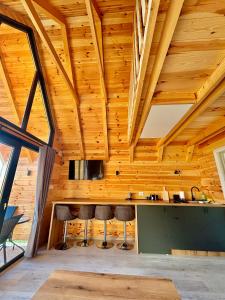 a room with wooden ceilings and stools at Eternum Glamping in Žabljak