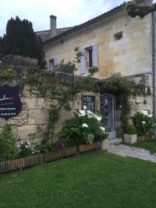 a building with a sign in front of a yard at Les Chambres d'Ovaline in Saint-Émilion