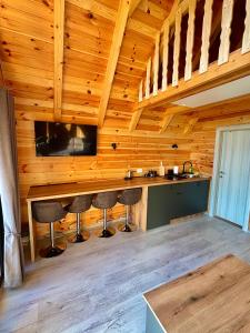 a kitchen with a bar in a wooden cabin at Eternum Glamping in Žabljak