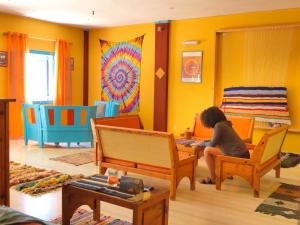 a woman sitting on a chair in a living room at Chrissi Ammos in Perissa