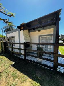 ein Haus mit einem Zaun davor in der Unterkunft Casa en Paso de la Patria in San Cosme